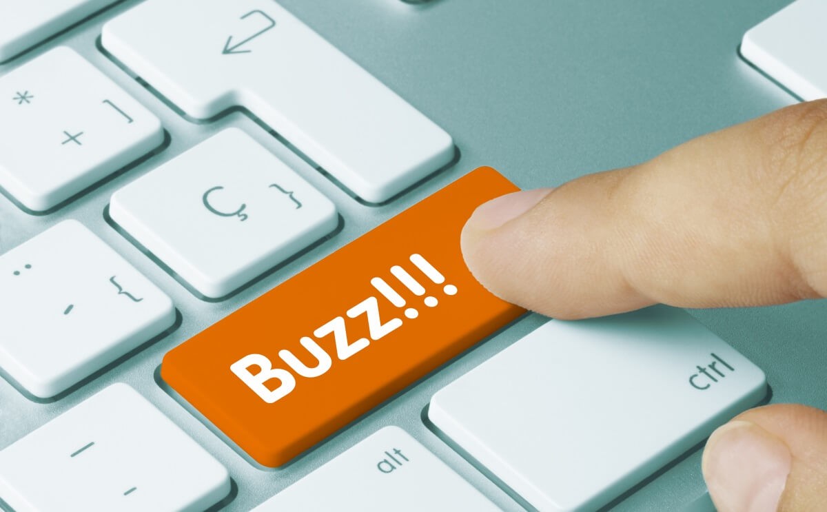 a finger pressing a key on a keyboard that says Buzz